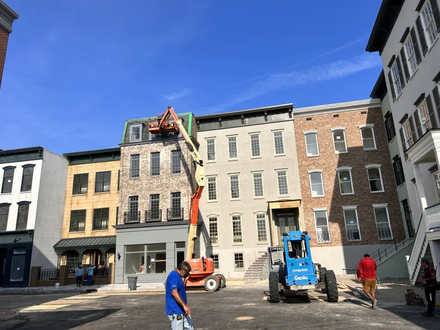 Boom lift raised to a top-floor cornice while the crew works the street elevation below